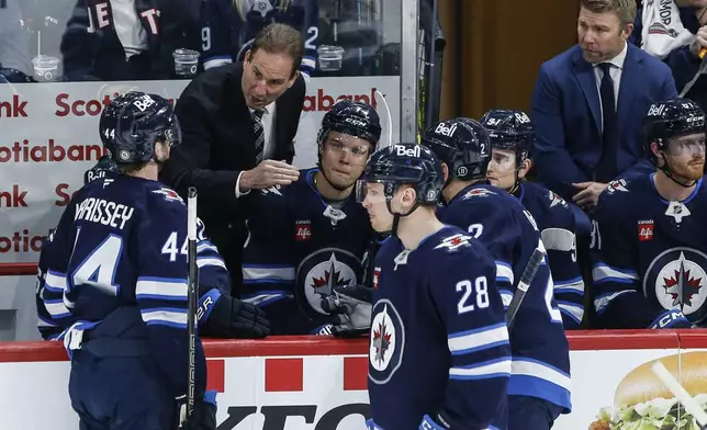 Winnipeg Jets head coach Scott Arniel, top left, talks to his team during first-period NHL hockey game action against the St. Louis Blues in Winnipeg, Manitoba, Monday, April 7, 2025. (John Woods/The Canadian Press via AP)
