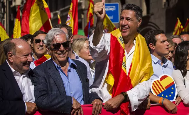 FILE - Nobel laureate Mario Vargas Llosa, second from left, stands next to Popular Party leader in Catalonia Xavier Garcia Albiol, right, as they lead a march to protest the Catalan government's push for secession from the rest of Spain in downtown Barcelona, Spain, Oct. 8, 2017. (AP Photo/Emilio Morenatti, File)
