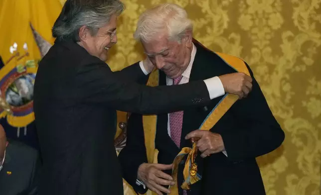 FILE - Ecuador's President Guillermo Lasso, left, honors writer Mario Vargas Llosa with the medal of "merit in the Order of the Grand Cross" in recognition of the writer's contribution to world literature, in Quito, Ecuador, Sept. 27, 2021. (AP Photo/Dolores Ochoa, File)