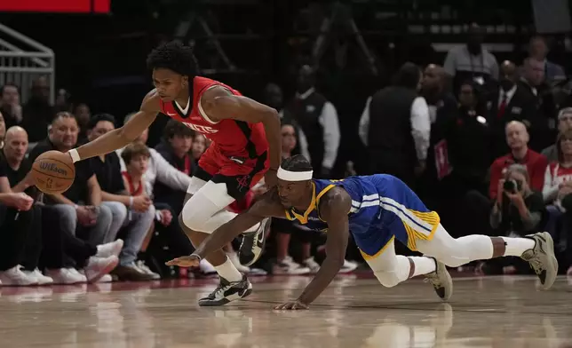 Houston Rockets forward Amen Thompson (1) takes control of the ball from Golden State Warriors forward Jimmy Butler III (10) during the second half of Game 1 of an NBA basketball first-round playoff series in Houston, Sunday, April 20, 2025. (AP Photo/Ashley Landis)