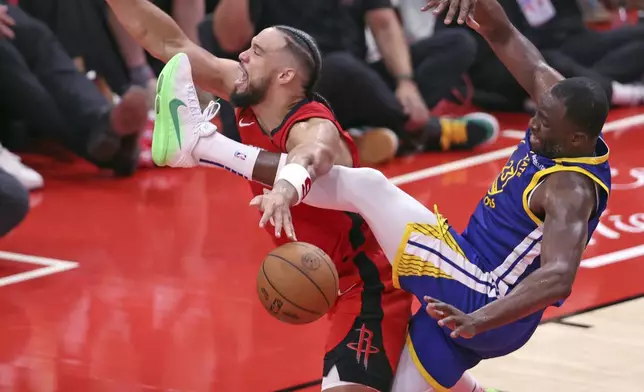 Golden State Warriors' Draymond Green, right, fouls Houston Rockets' Dillon Brooks in the second half of Game 1 of an NBA basketball first-round playoff series in Houston Sunday, April 20, 2025. (Scott Strazzante/San Francisco Chronicle via AP)