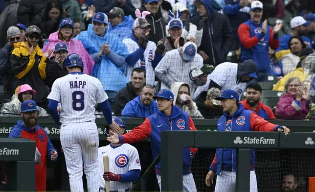 Chicago Cubs' Ian Happ (8) celebrates with manager Craig Counsell right, at the dugout after scoring on a Michael Busch single during the first inning of a baseball game against the Arizona Diamondbacks Sunday, April 20, 2025, in Chicago. (AP Photo/Paul Beaty)