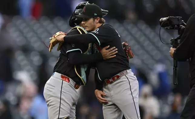 Arizona Diamondbacks closing pitcher Drey Jameson right, celebrates with catcher Jose Herrera left, after defeating the Chicago Cubs in a baseball game Sunday, April 20, 2025, in Chicago. (AP Photo/Paul Beaty)