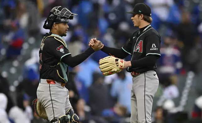 Arizona Diamondbacks closing pitcher Drey Jameson right, celebrates with catcher Jose Herrera left, after defeating the Chicago Cubs in a baseball game Sunday, April 20, 2025, in Chicago. (AP Photo/Paul Beaty)