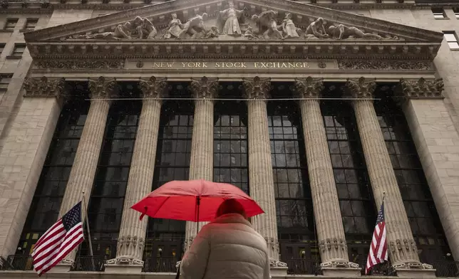 A person stands in front of the New York Stock Exchange, Monday, April 7, 2025, in New York. (AP Photo/Yuki Iwamura)