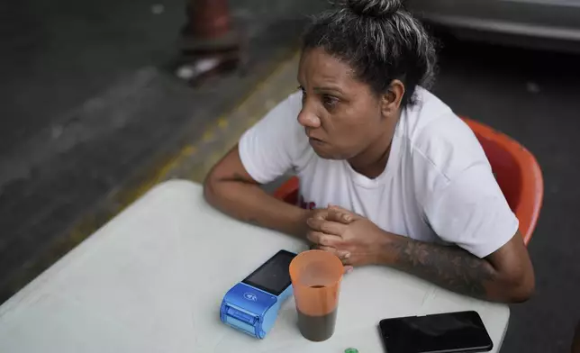A street food vendor waits for patrons in Caracas, Venezuela, Thursday, April 10, 2025. (AP Photo/Ariana Cubillos)