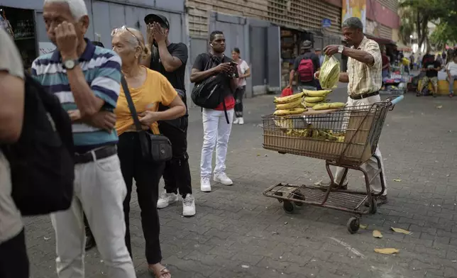 Arnold Guerrero sells plantains in the street in Caracas, Venezuela, Friday, April 11, 2025. (AP Photo/Ariana Cubillos)