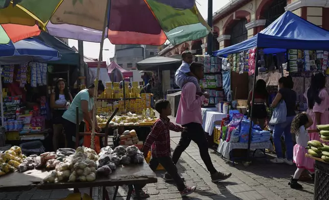 Venders sell in the street in Caracas, Venezuela, Friday, April 11, 2025. (AP Photo/Ariana Cubillos)