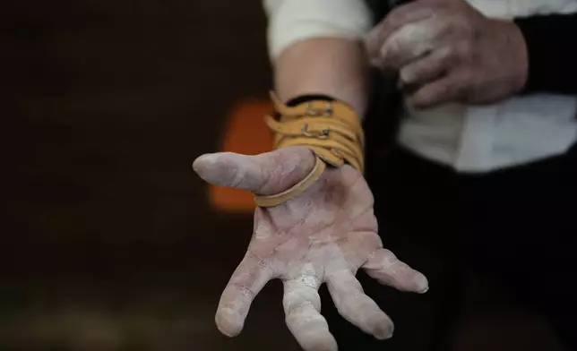 A competitor warms up for his bout while he try to pull the opponent over the table at the German Championships in Fingerhakeln or finger wrestling, in Pang, near Rosenheim, Germany, Sunday, April 27, 2025. (AP Photo/Matthias Schrader)