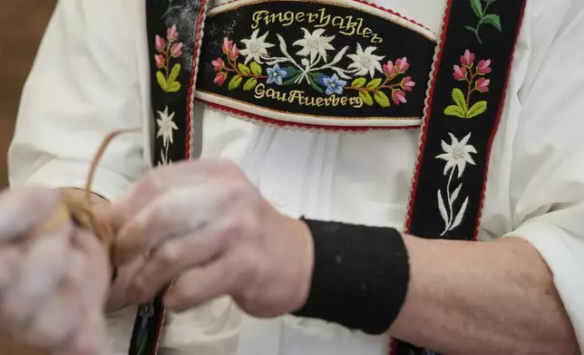 A competitor warms up for his bout while he try to pull the opponent over the table at the German Championships in Fingerhakeln or finger wrestling, in Pang, near Rosenheim, Germany, Sunday, April 27, 2025. (AP Photo/Matthias Schrader)