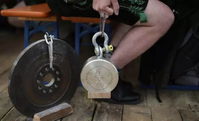 A competitor warms up for his bout while he try to pull the opponent over the table at the German Championships in Fingerhakeln or finger wrestling, in Pang, near Rosenheim, Germany, Sunday, April 27, 2025. (AP Photo/Matthias Schrader)