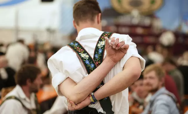 A competitor warms up for his bout while he try to pull the opponent over the table at the German Championships in Fingerhakeln or finger wrestling, in Pang, near Rosenheim, Germany, Sunday, April 27, 2025. (AP Photo/Matthias Schrader)