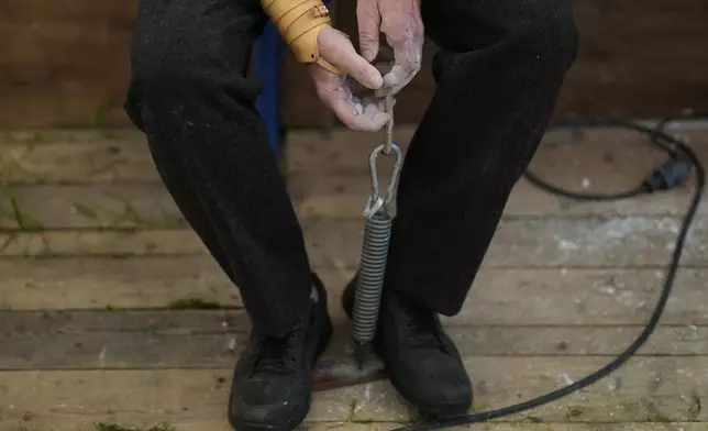 A competitor warms up for his bout while he tries to pull the opponent over the table at the German Championships in Fingerhakeln or finger wrestling, in Pang, near Rosenheim, Germany, Sunday, April 27, 2025. (AP Photo/Matthias Schrader)