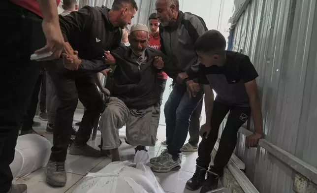Relatives mourn over the bodies of several members of the Abu Mahdi family, killed in an Israeli army airstrike, during their funeral at the Indonesian hospital in Beit Lahia, northern Gaza Strip, Monday, April 28, 2025. (AP Photo/Jehad Alshrafi)