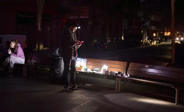A man sells battery-powered radios and torches on a Barcelona street during the blackout in Barcelona, Spain, Tuesday, April 29, 2025. (AP Photo/Emilio Morenatti)