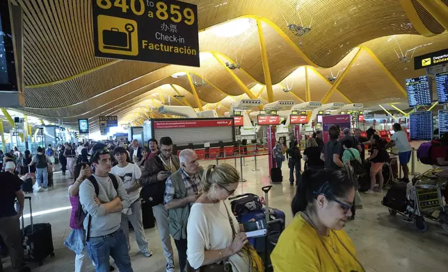 Passengers queue inside Madrid airport, during a nationwide power outage, Monday, April 28, 2025. (AP Photo/Manu Fernandez)