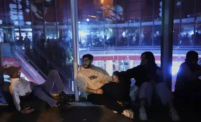 People gather in Atocha train station during a major power outage in Madrid, Monday, April 28, 2025. (AP Photo/Manu Fernandez)