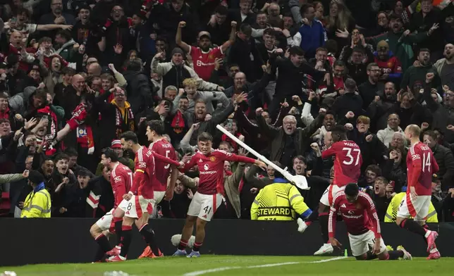 Manchester United's Harry Maguire, left, celebrates with team mates after his side's fifth goal during the Europa League quarter final second leg soccer match between Manchester United and Olympique Lyon in Manchester, Britain, Thursday, April 17, 2025. (AP Photo/Jon Super)