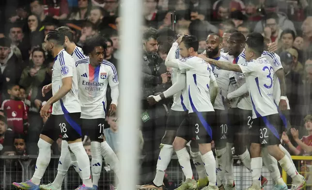 Lyon's Nicolas Tagliafico, center, celebrates with team mates after scoring his side's second goal during the Europa League quarter final second leg soccer match between Manchester United and Olympique Lyon in Manchester, Britain, Thursday, April 17, 2025. (AP Photo/Jon Super)