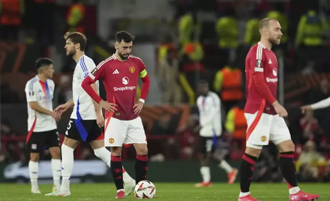 Manchester United’s Bruno Fernandes reacts after Lyon's Alexandre Lacazette scored during the Europa League quarter final second leg soccer match between Manchester United and Olympique Lyon in Manchester, Britain, Thursday, April 17, 2025. (AP Photo/Jon Super)