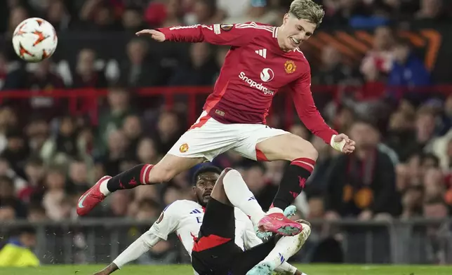 Manchester United's Alejandro Garnacho, top, and Lyon's Ainsley Maitland-Niles challenge for the ball during the Europa League quarter final second leg soccer match between Manchester United and Olympique Lyon in Manchester, Britain, Thursday, April 17, 2025. (AP Photo/Jon Super)