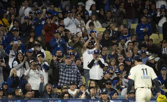 Los Angeles Dodgers fans applaud after starting pitcher Roki Sasaki is being substituted during the sixth inning of a baseball game between the Los Angeles Dodgers and the Pittsburgh Pirates in Los Angeles, Saturday, April 26, 2025. (AP Photo/Kyusung Gong)