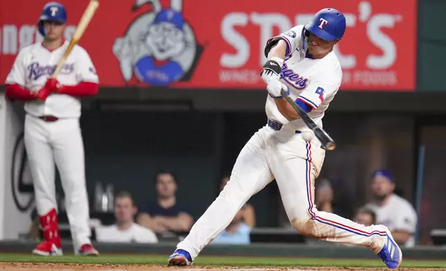 Texas Rangers' Corey Seager connects for a hit in the fifth inning of a baseball game against the Los Angeles Angels Wednesday, April 16, 2025, in Arlington, Texas. (AP Photo/Julio Cortez)