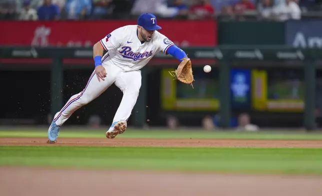 Texas Rangers first base Jake Burger fields a groundout by Los Angeles Angels' Luis Rengifo during the first inning of a baseball game Wednesday, April 16, 2025, in Arlington, Texas. (AP Photo/Julio Cortez)