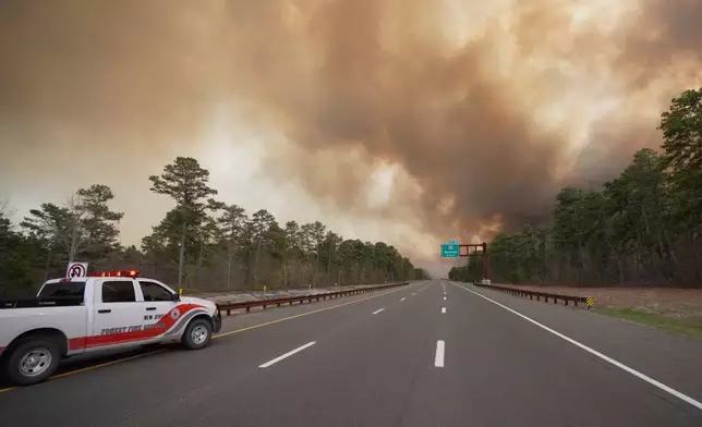 Smoke fills the sky as firefighters battle a wildfire in Lacey Townships, N.J. on Tuesday, April 22, 2025. (New Jersey Department of Environmental Protection via AP)