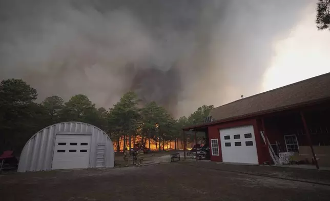 Smoke fills the sky as firefighters battle a wildfire in Lacey Townships, N.J. on Tuesday, April 22, 2025. (New Jersey Department of Environmental Protection via AP)