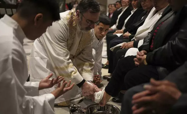Theodoros Kondidis S.J., Catholic Archbishop of Athens, washes the feet of a woman during the Mass of Last Supper at the Catholic Cathedral Basilica of St Dionysius the Areopagite in Athens, Greece, Holy Thursday, April 17, 2025. (AP Photo/Thanassis Stavrakis)