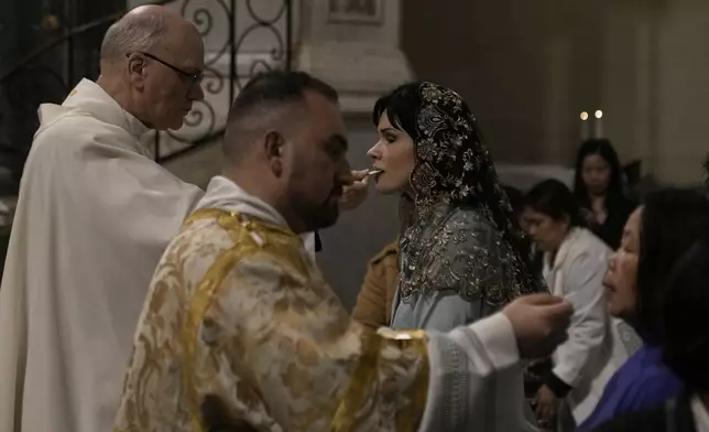 Greek Catholic believers and foreigners who live in Greece take communion during the Mass of Last Supper at the Catholic Cathedral Basilica of St Dionysius the Areopagite in Athens, Greece, Holy Thursday, April 17, 2025. (AP Photo/Thanassis Stavrakis)
