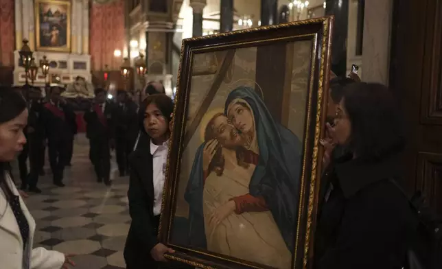 Greek Catholic believers and foreigners who live in Greece attend the Epitaph Procession at the Catholic Cathedral Basilica of St Dionysius the Areopagite in Athens, Greece, Good Friday, April 18, 2025. (AP Photo/Thanassis Stavrakis)