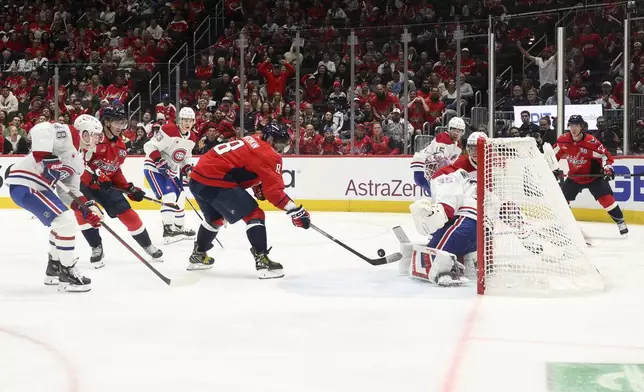 Washington Capitals left wing Alex Ovechkin (8) shoots the winning goal against Montreal Canadiens goaltender Sam Montembeault (35) in the overtime of Game 1 of a first-round NHL hockey playoff series Monday, April 21, 2025, in Washington. (AP Photo/Nick Wass)