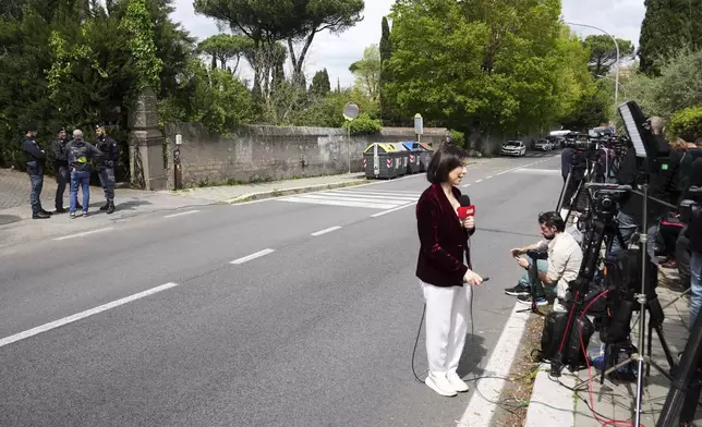 Police and reporters stand outside the Omani Embassy in Rome during a closed-door meeting between U.S. and Iranian delegations to discuss Tehran's rapidly advancing nuclear program, Saturday, April 19, 2025. (AP Photo/Andrew Medichini)