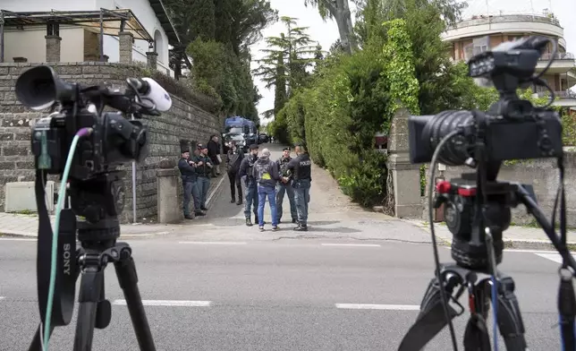 Police and reporters stand outside the Omani Embassy in Rome during a closed-door meeting between U.S. and Iranian delegations to discuss Tehran's rapidly advancing nuclear program, Saturday, April 19, 2025. (AP Photo/Andrew Medichini)