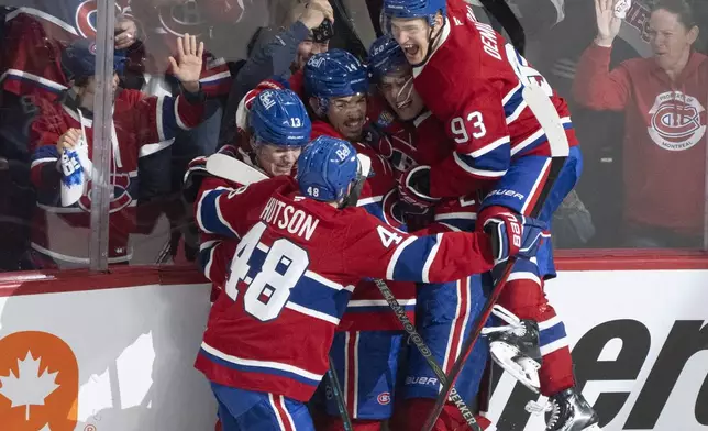 Montreal Canadiens' Nick Suzuki, center, celebrates his goal against the Washington Capitals with teammates during the second period of an NHL hockey playoff game in Montreal on Friday, April 25, 2025. (Christinne Muschi/The Canadian Press via AP)