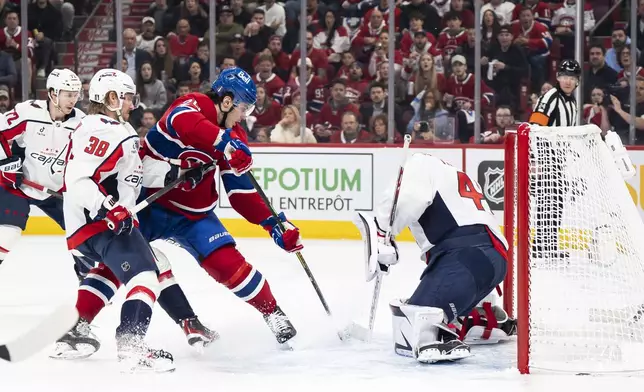 Montreal Canadiens' Juraj Slafkovsky, third from left, is stopped by Washington Capitals goaltender Logan Thompson, right, during the first period of Game 3 of a first-round NHL hockey playoff series in Montreal, Friday, April 25, 2025. (Christopher Katsarov/The Canadian Press via AP)