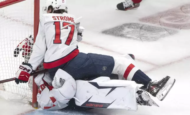 Washington Capitals' Dylan Strome (17) collides with goaltender Logan Thompson, bottom, during the third period of Game 3 of a first-round NHL hockey playoff series against the Montreal Canadiens in Montreal, Friday, April 25, 2025. (Christinne Muschi/The Canadian Press via AP)