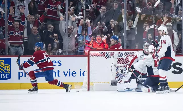 Montreal Canadiens' Nick Suzuki (14) scores against Washington Capitals goaltender Logan Thompson (48) during the second period of Game 3 of a first-round NHL hockey playoff series in Montreal, Friday, April 25, 2025. (Christopher Katsarov/The Canadian Press via AP)