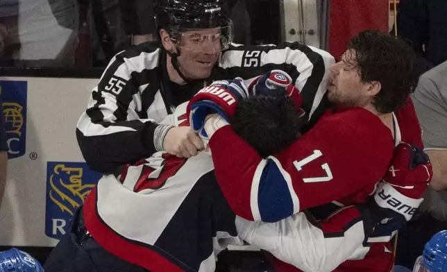 A referee (55) tries to separate Montreal Canadiens' Josh Anderson (17) and Washington Capitals' Tom Wilson, front left, as they fight following the second period of Game 3 of a first-round NHL hockey playoff series in Montreal, Friday, April 25, 2025. (Christinne Muschi/The Canadian Press via AP)