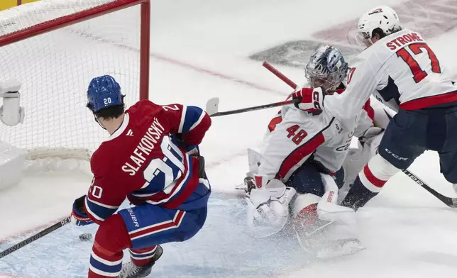 Montreal Canadiens' Juraj Slafkovsky (20) scores against Washington Capitals goaltender Logan Thompson (48) as Capitals' Dylan Strome (17) skates in during the third period of Game 3 of a first-round NHL hockey playoff series in Montreal, Friday, April 25, 2025. (Christinne Muschi/The Canadian Press via AP)