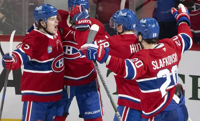 Montreal Canadiens' Cole Caufield (13) celebrates after his goal against the Washington Capitals with teammates Nick Suzuki (14), Lane Hutson (48) and Juraj Slafkovsky (20) during the second period of Game 3 of a first-round NHL hockey playoff series in Montreal, Friday, April 25, 2025. (Christinne Muschi/The Canadian Press via AP)