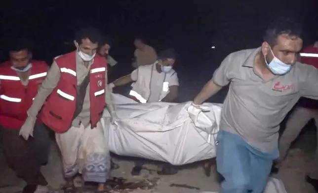 This photo taken from video released by Al Masirah TV channel shows medics carrying a dead person after U.S. airstrikes targeted the Ras Isa oil port held by Yemen's Houthi rebels in Hodeida, Yemen, Friday, April 18, 2025.( Al Masirah TV via AP)