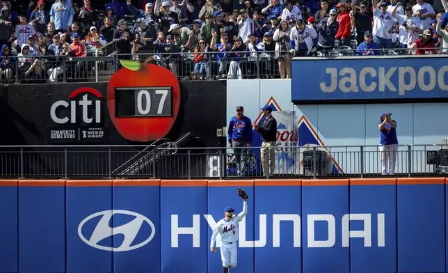 New York Mets outfielder Brandon Nimmo (9) and fans celebrate his leaping catch during the sixth inning of the baseball game against the St. Louis Cardinals, Sunday, April 20, 2025, in New York. (AP Photo/Angelina Katsanis)
