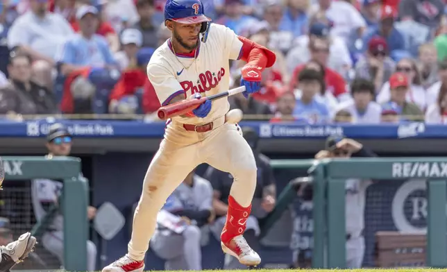 Philadelphia Phillies' Johan Rojas bunts in the sixth inning of a baseball game against the Miami Marlins, Sunday, April 20, 2025, in Philadelphia. (AP Photo/Laurence Kesterson)