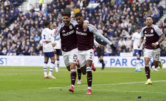 Aston Villa's Marcus Rashford, center right, celebrates scoring their side's first goal of the game with teammate Marco Asensio during the English FA Cup quarter final soccer match at Deepdale, Preston, England, Sunday, March 30, 2025. (Martin Rickett/PA via AP)