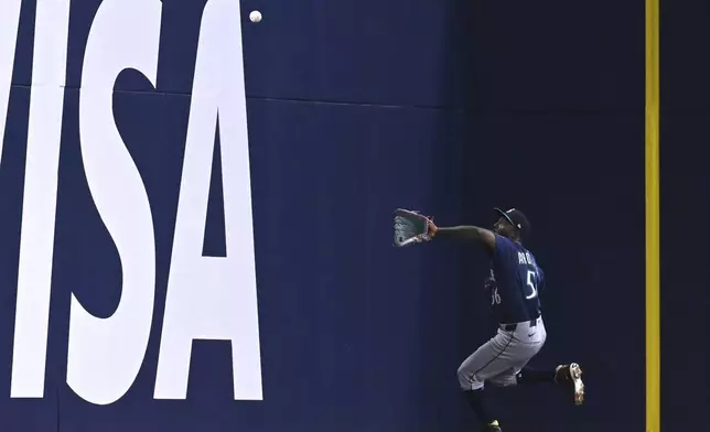 Seattle Mariners left fielder Randy Arozarena (56) catches a fly ball off the bat of Toronto Blue Jays' Andres Gimenez, not pictured, in the second inning of a baseball game in Toronto on Sunday, April 20, 2025. (Jon Blacker/The Canadian Press via AP)