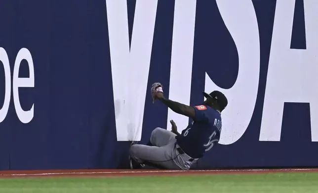 Seattle Mariners left fielder Randy Arozarena (56) catches a fly ball off the bat of Toronto Blue Jays' Andres Gimenez, not pictured, in the second inning of a baseball game in Toronto on Sunday, April 20, 2025. (Jon Blacker/The Canadian Press via AP)