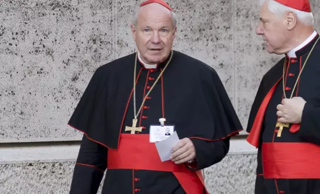 FILE - Austrian Cardinal Christoph Schoenborn, left, and German Cardinal Gerhard Ludwig Mueller arrive for the morning session of the synod on the family, a two-week meeting of 200 cardinals and bishops from around the world, at the Vatican on Oct. 9, 2014. (AP Photo/Alessandra Tarantino, File)